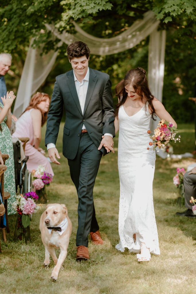 Bride & groom walking down the aisle with their dog