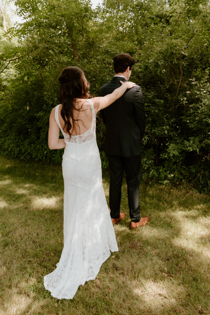 The bride tapping the groom on their shoulder before their first look