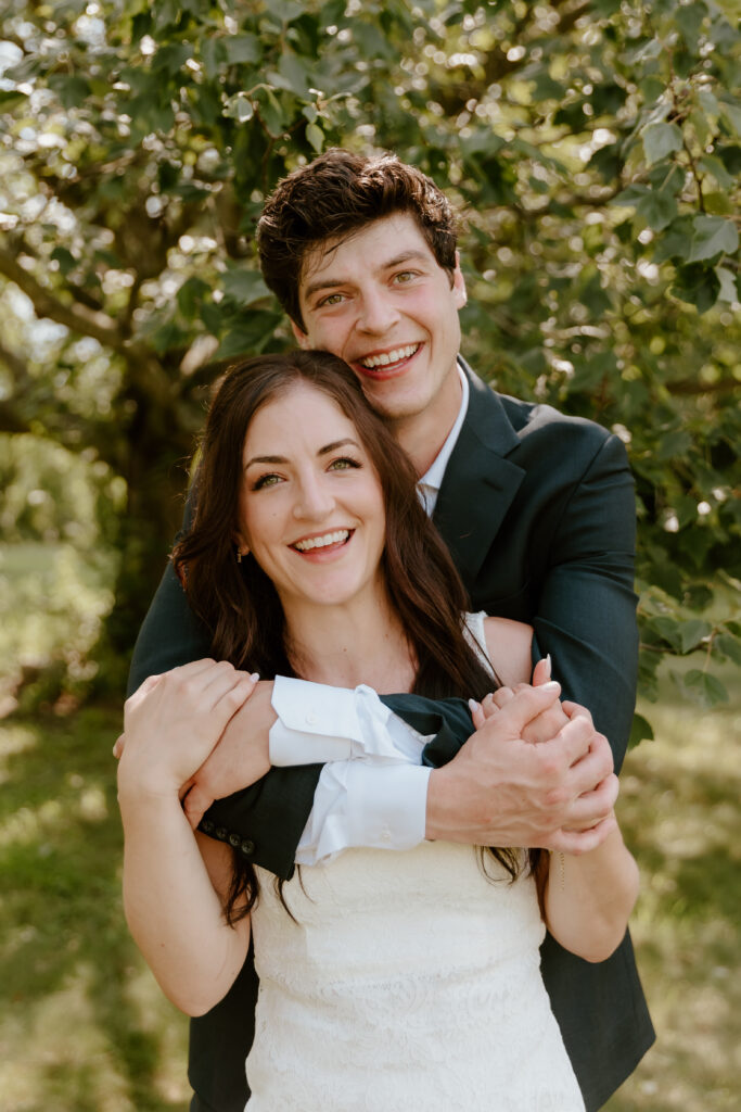 The bride & groom smiling at the camera