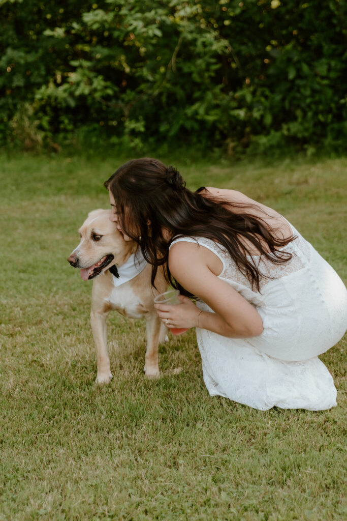 The bride kissing her faithful dog in her backyard