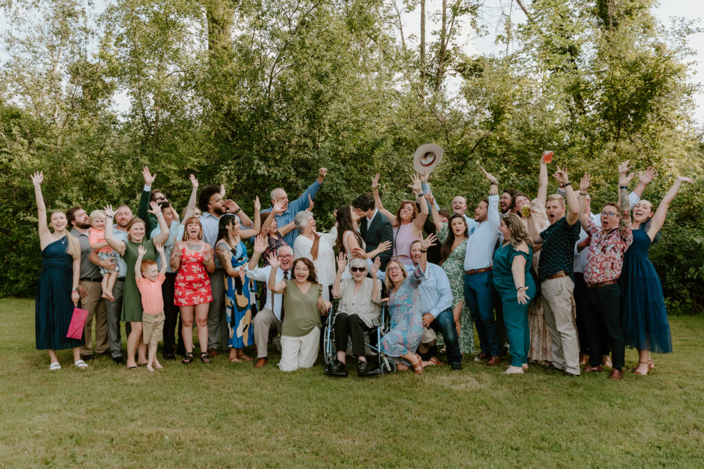 All of the backyard wedding guests surrounding the bride & groom and cheering them on while they kiss