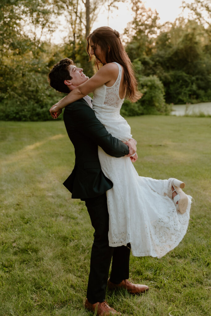 The groom picking up his bride during golden hour portraits