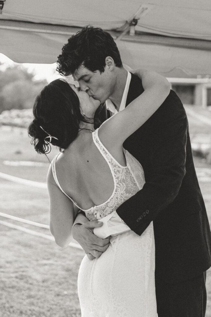 The bride and groom kissing during their first dance together